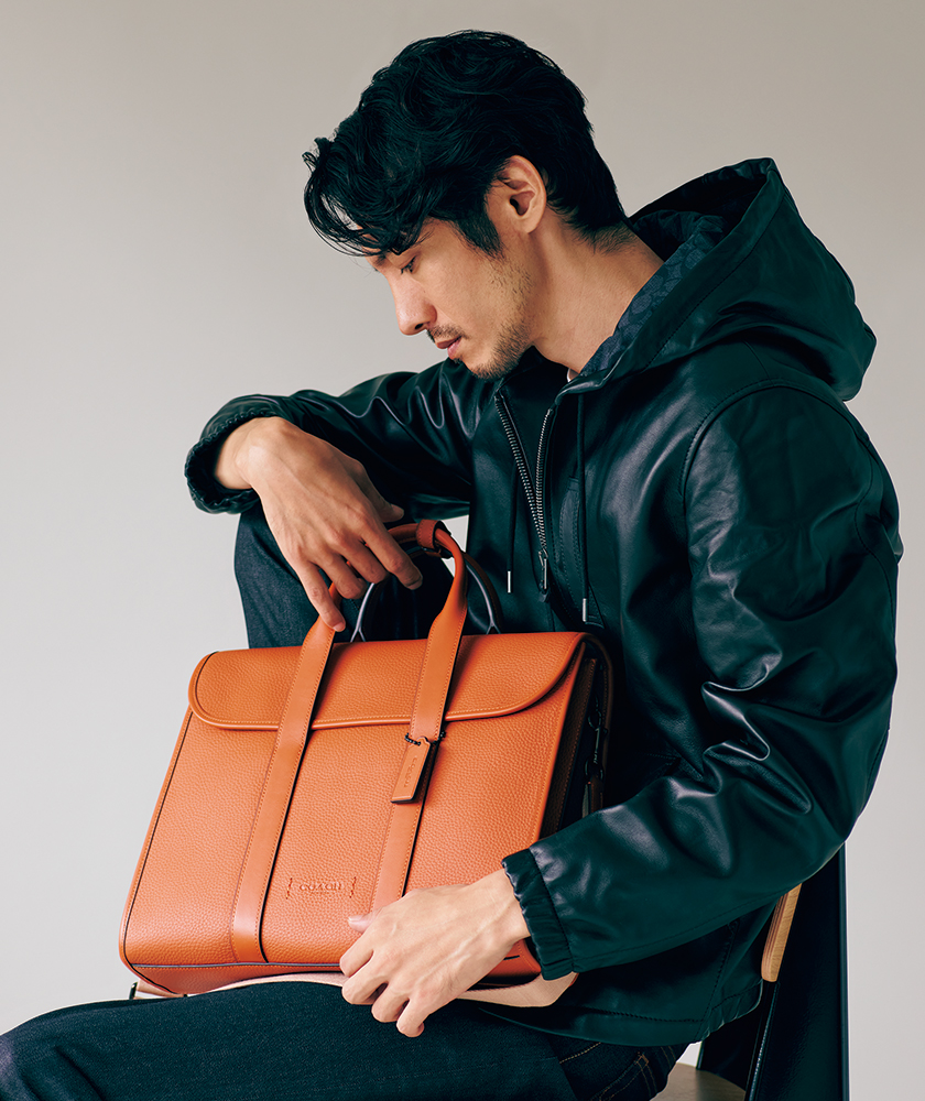 コーチの鮮烈な「オレンジバッグ」が秋冬の黒一張羅アウターを活かす話